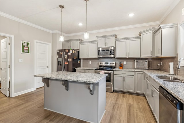 1025 Brightwood Ct, Clarksville, TN 37043 - kitchen with light wood finished floors, gray cabinetry, a kitchen island, appliances with stainless steel finishes, and a sink