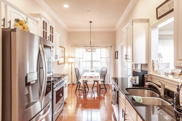 kitchen featuring a sink, dark stone countertops, appliances with stainless steel finishes, crown molding, and glass insert cabinets