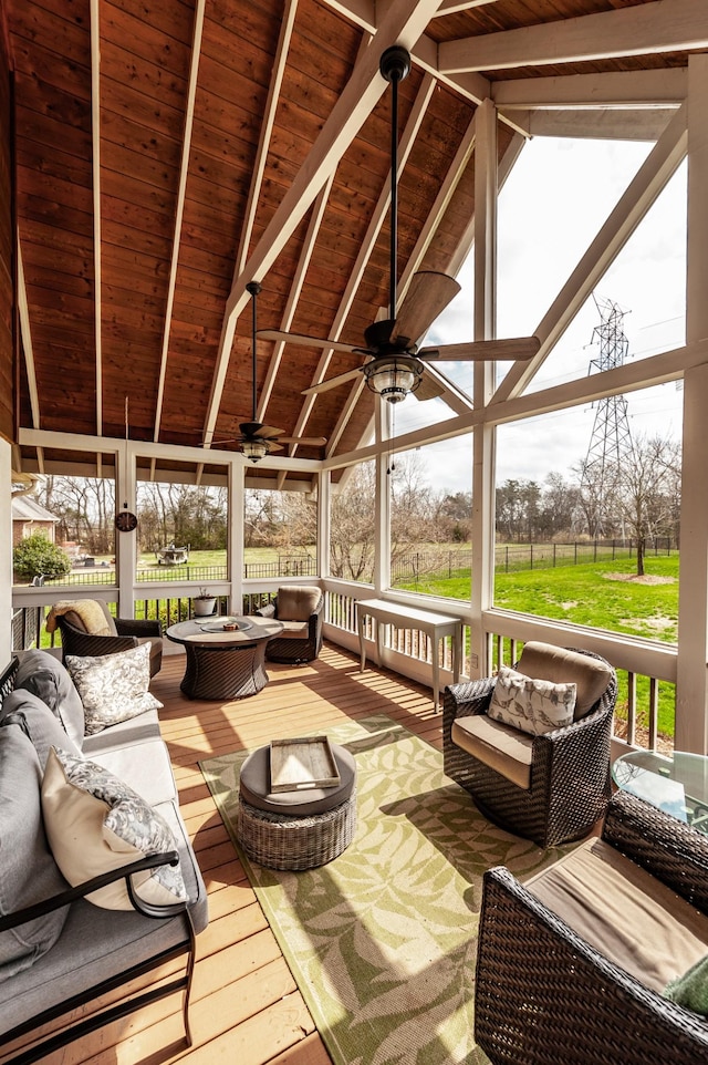 sunroom / solarium featuring vaulted ceiling with beams, a healthy amount of sunlight, wooden ceiling, and a ceiling fan