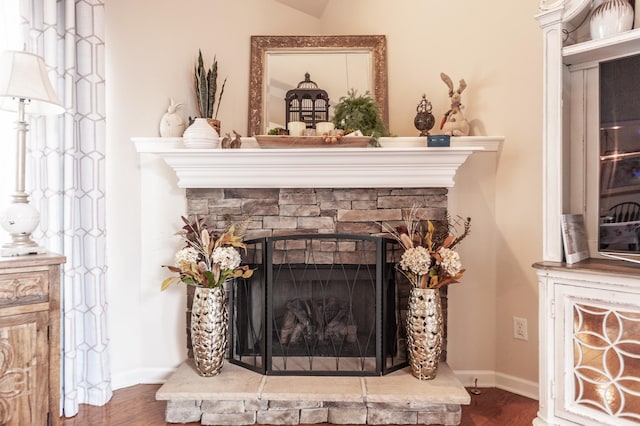 room details with a fireplace, baseboards, and wood finished floors