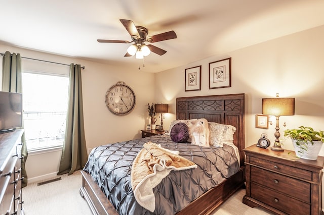 bedroom with visible vents, baseboards, light carpet, and ceiling fan