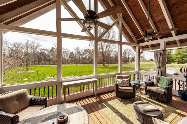 sunroom / solarium featuring lofted ceiling with beams, ceiling fan, and wooden ceiling