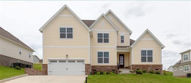 craftsman house with a front lawn, an attached garage, and driveway