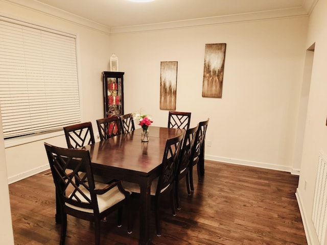 dining room featuring dark wood finished floors, baseboards, and ornamental molding