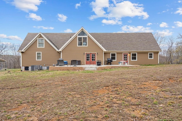 rear view of house featuring cooling unit, a patio, and roof with shingles