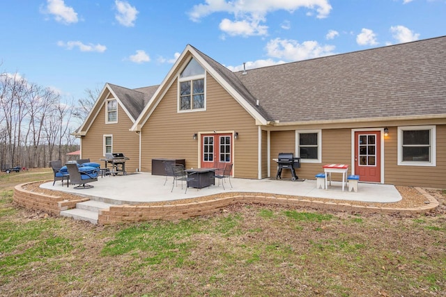 back of house featuring roof with shingles and a patio area