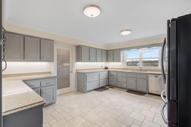 kitchen featuring a sink, gray cabinetry, ornamental molding, and appliances with stainless steel finishes