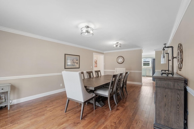 dining room with light wood finished floors, baseboards, and ornamental molding