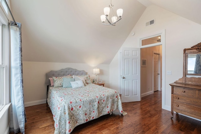 bedroom with lofted ceiling, a notable chandelier, wood finished floors, and visible vents