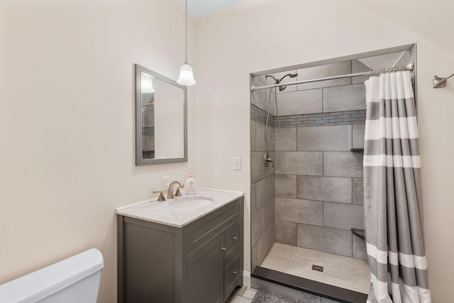 full bath with vanity, toilet, and tiled shower