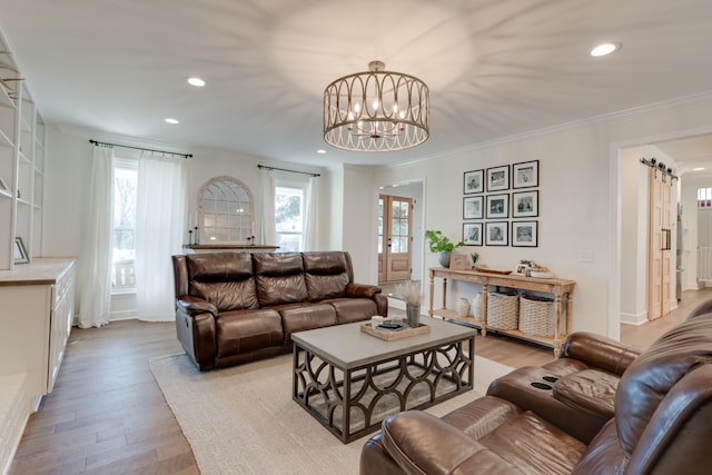 living room featuring recessed lighting, a chandelier, light wood-style floors, and ornamental molding