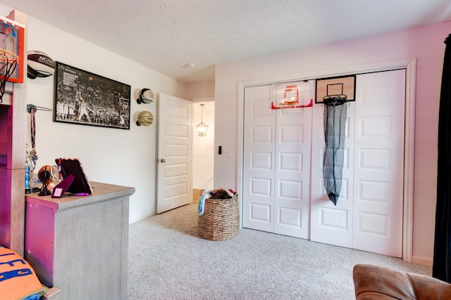 carpeted bedroom with a closet and a textured ceiling