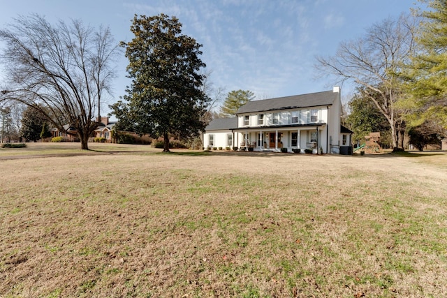 back of property with a lawn and covered porch