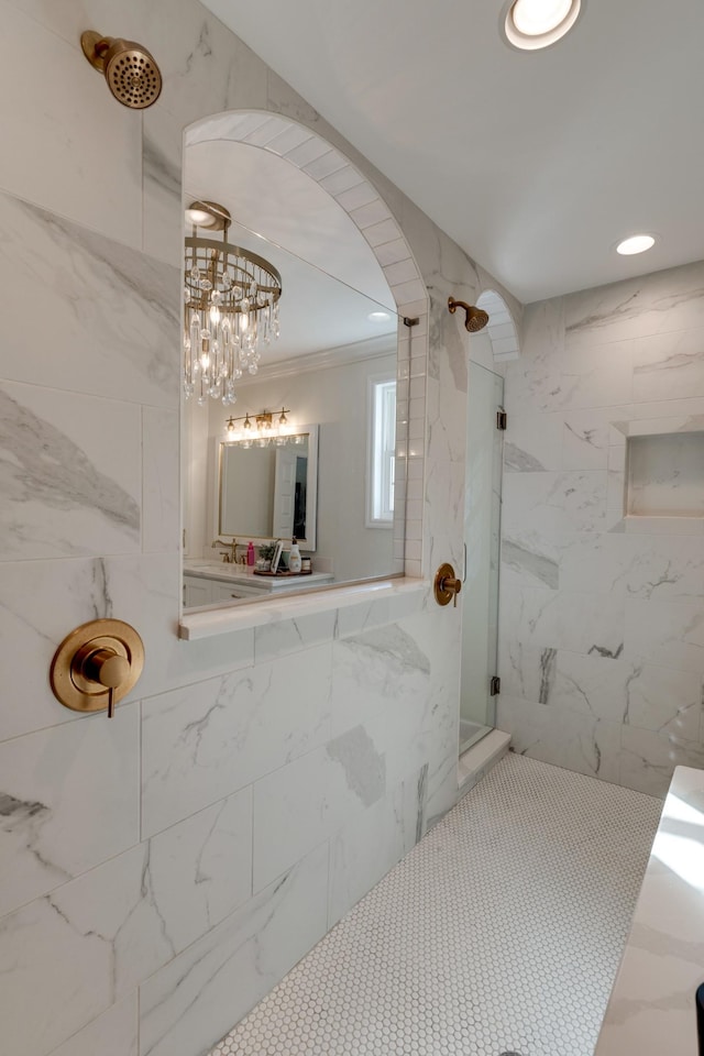 full bath with recessed lighting, a marble finish shower, an inviting chandelier, and ornamental molding