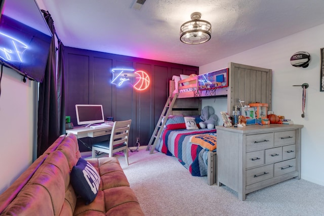 bedroom with visible vents, light colored carpet, a textured ceiling, and a decorative wall