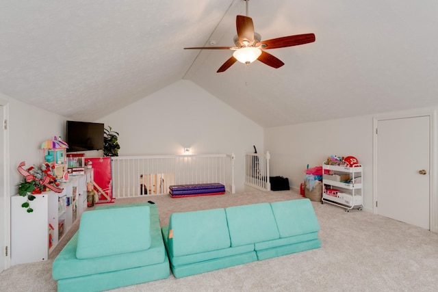 living room with carpet floors, a textured ceiling, ceiling fan, and vaulted ceiling