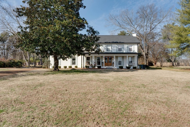 view of front of home featuring covered porch, a front lawn, and stucco siding