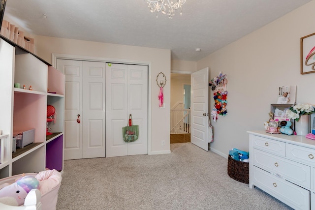 carpeted bedroom featuring a closet, baseboards, and a notable chandelier