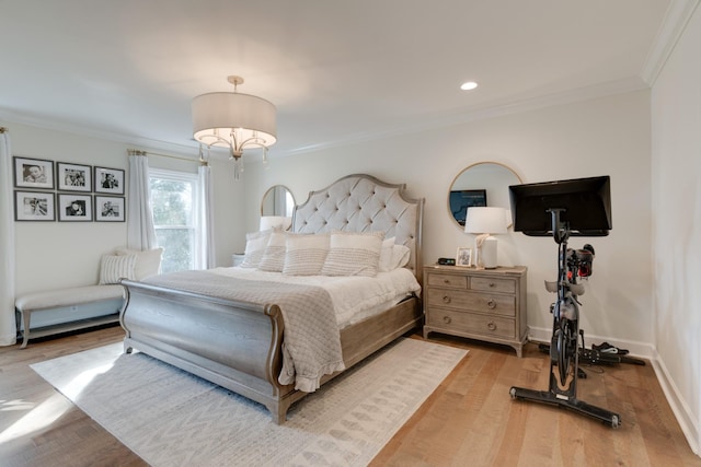 bedroom with crown molding, wood finished floors, and baseboards