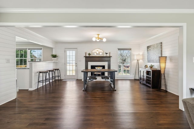 dining space featuring dark wood-type flooring, plenty of natural light, and crown molding