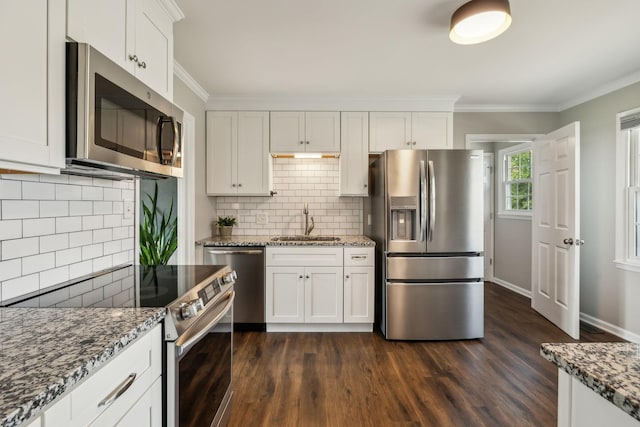 kitchen featuring dark wood-style flooring, a sink, stainless steel appliances, white cabinets, and crown molding