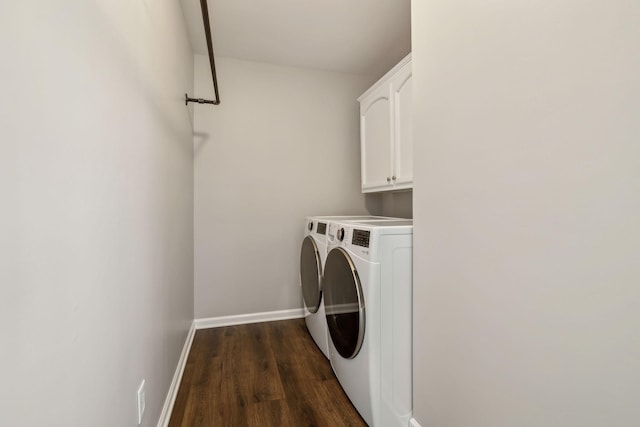 clothes washing area with baseboards, cabinet space, dark wood finished floors, and washer and clothes dryer