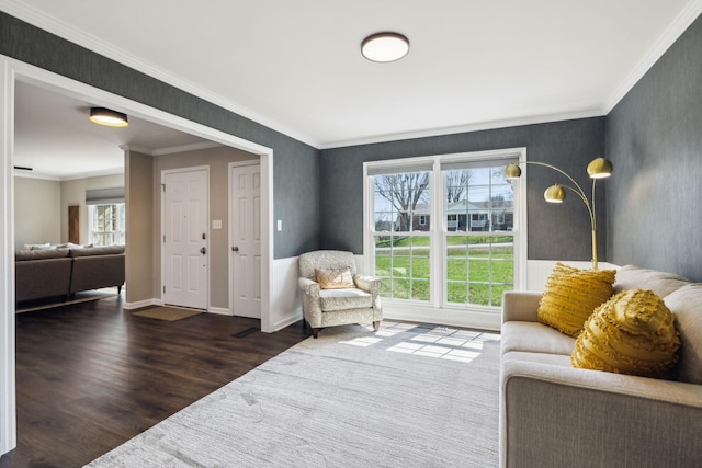 living area with a wealth of natural light, crown molding, baseboards, and wood finished floors