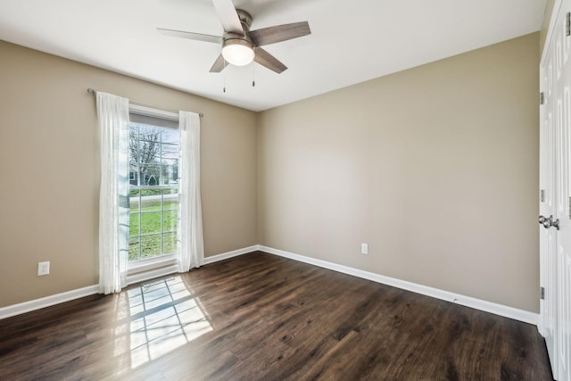 empty room with baseboards, dark wood-style flooring, and a ceiling fan