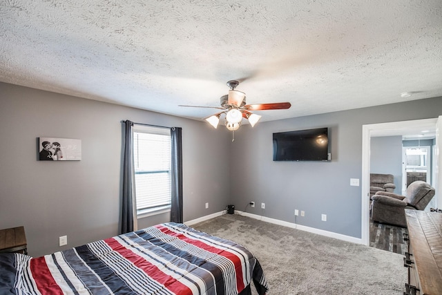 bedroom featuring a textured ceiling, a ceiling fan, baseboards, and carpet floors