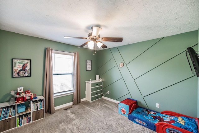 bedroom featuring visible vents, baseboards, carpet floors, ceiling fan, and a textured ceiling