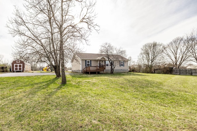 view of front of house featuring a front yard, fence, an outdoor structure, crawl space, and a storage shed