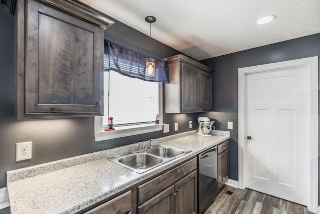 kitchen featuring a sink, dark brown cabinetry, dishwasher, light countertops, and dark wood-style flooring