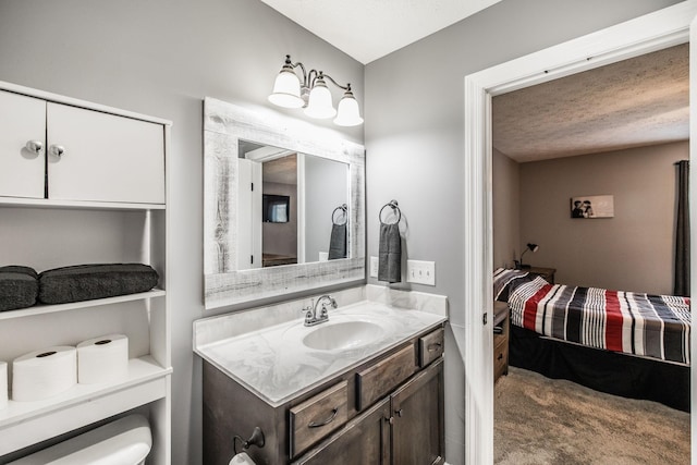 ensuite bathroom featuring ensuite bathroom, a textured ceiling, vanity, and toilet