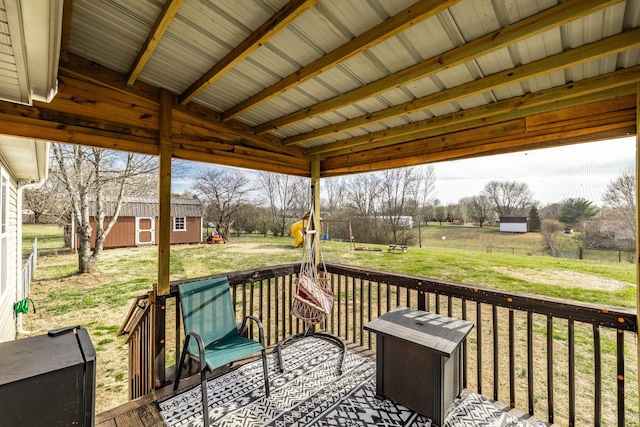 deck featuring a storage shed, an outbuilding, and a yard