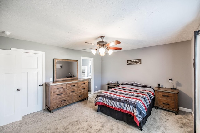 bedroom featuring baseboards, light colored carpet, a ceiling fan, and a textured ceiling