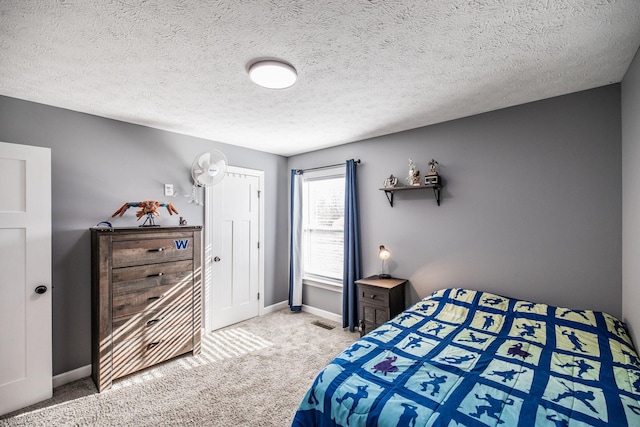 carpeted bedroom with visible vents, baseboards, and a textured ceiling