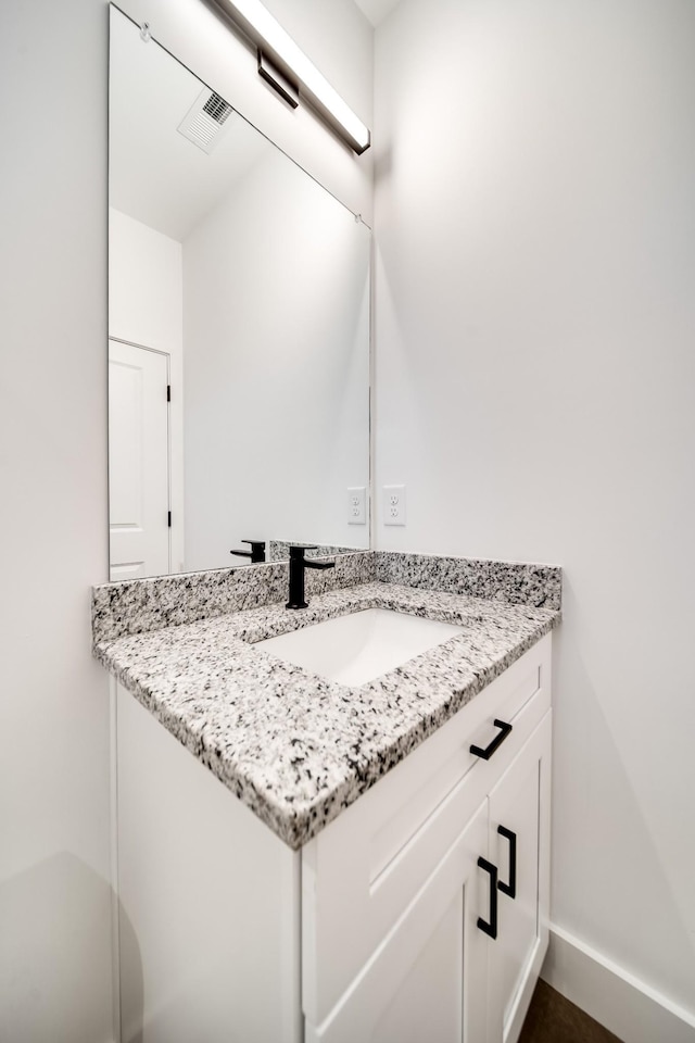 bathroom with visible vents, vanity, and baseboards