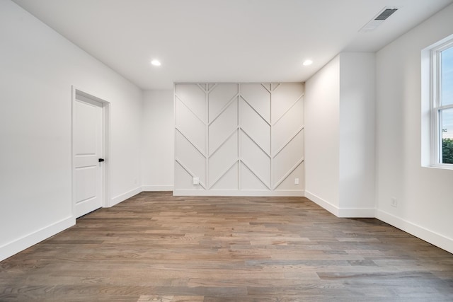 spare room featuring recessed lighting, visible vents, baseboards, and wood finished floors