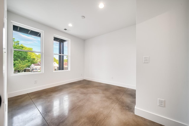 unfurnished room with visible vents, recessed lighting, baseboards, and finished concrete floors