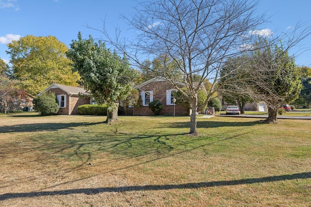 view of front of house featuring brick siding and a front yard