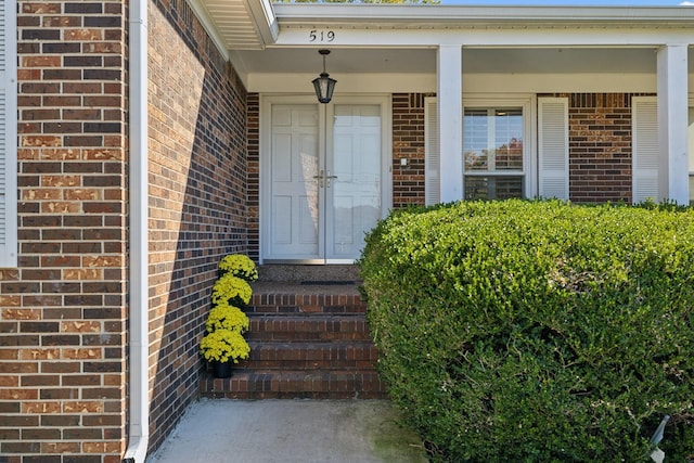 doorway to property featuring brick siding