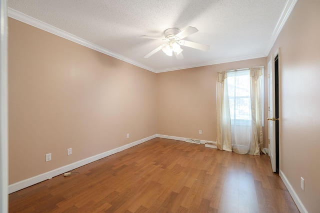 spare room with a ceiling fan, a textured ceiling, light wood-style floors, crown molding, and baseboards