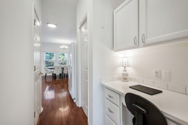 office area with a notable chandelier and dark wood finished floors