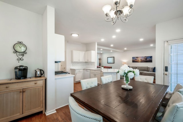 dining area with an inviting chandelier, recessed lighting, and dark wood-style flooring