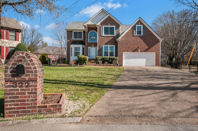 view of front of property with brick siding, driveway, a front lawn, and fence