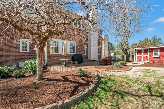 back of house featuring fence, entry steps, crawl space, a patio area, and brick siding