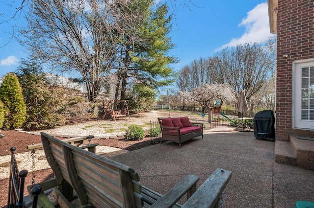 view of patio / terrace featuring area for grilling, a playground, and fence