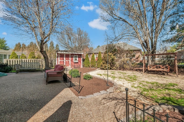 view of yard with a storage shed, an outdoor structure, and fence