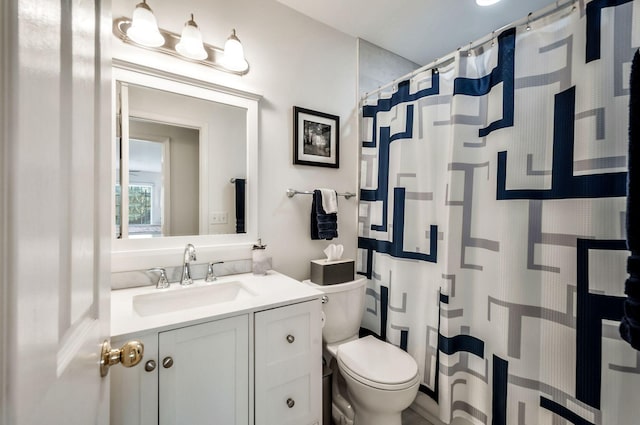 bathroom featuring vanity, a shower with shower curtain, and toilet