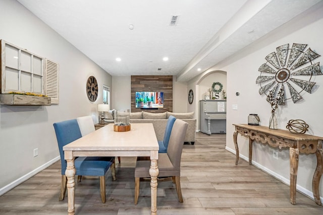 dining room with visible vents, recessed lighting, arched walkways, light wood-style floors, and baseboards